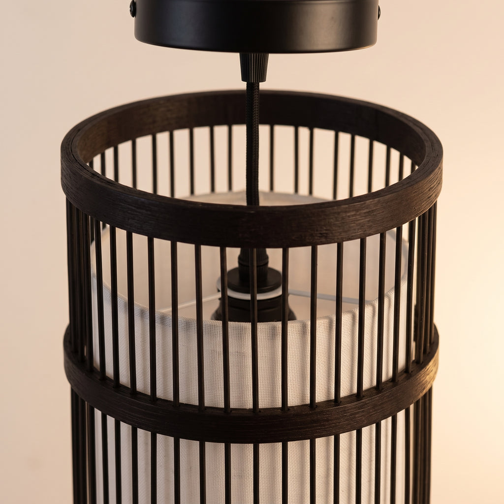 Gros plan sur le tressage et la finition : suspension en bambou cylindre noir