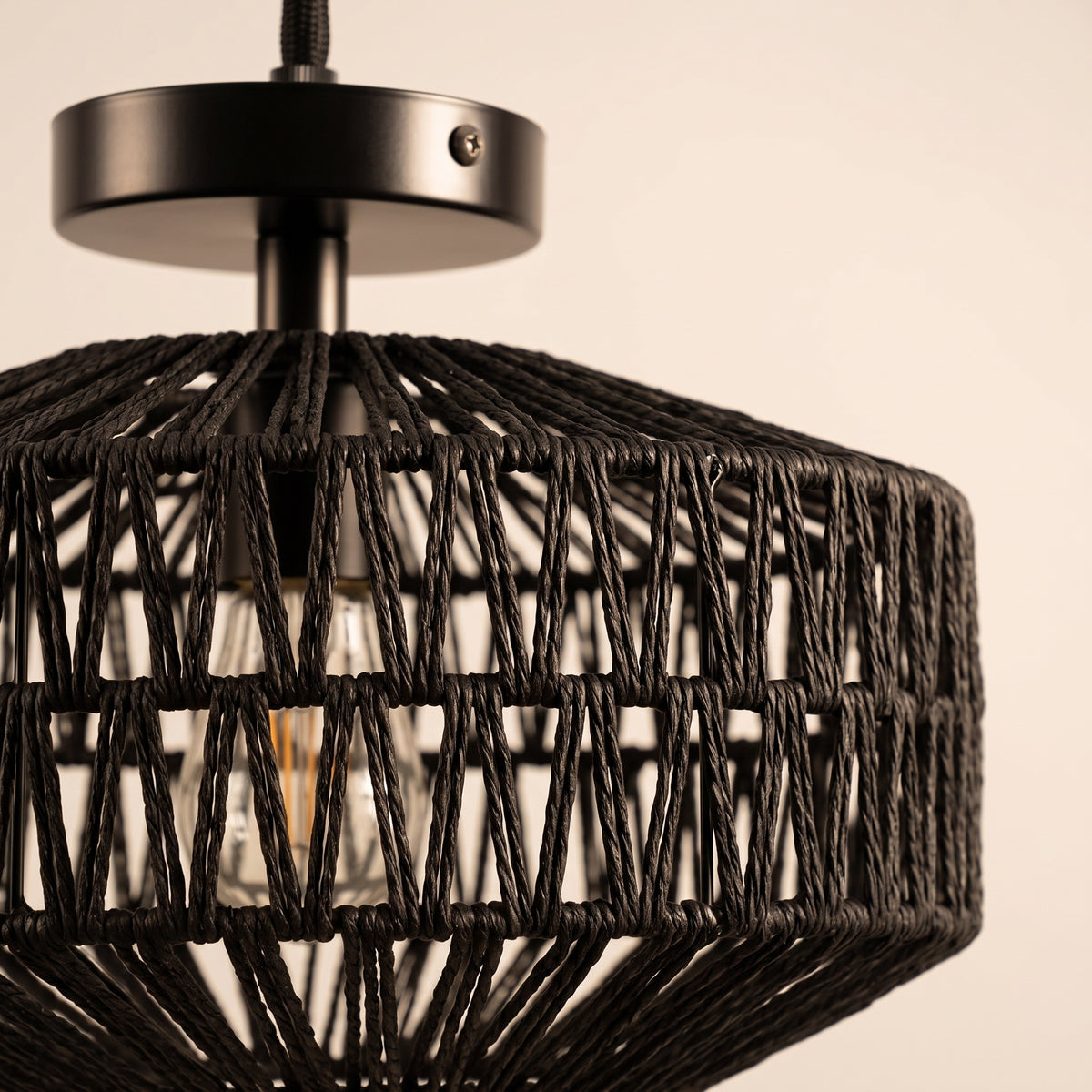Gros plan sur le tressage et la finition : plafonnier tambour en corde de papier noire