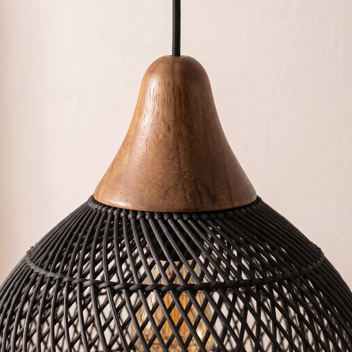 Gros plan sur le tressage noir et le chapeau en bois de la suspension arrondie