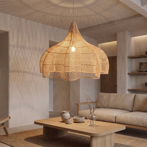 Grande suspension en rotin forme citrouille allumée le soir dans un grand salon japandi
