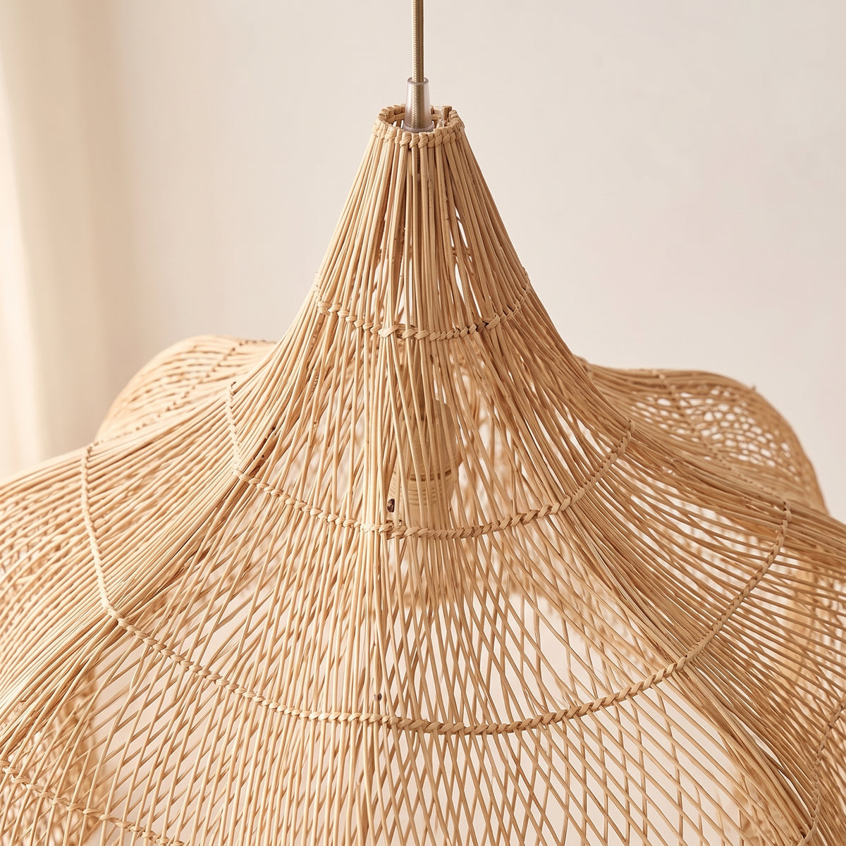 Gros plan sur le tressage et la finition : grande suspension en rotin forme citrouille