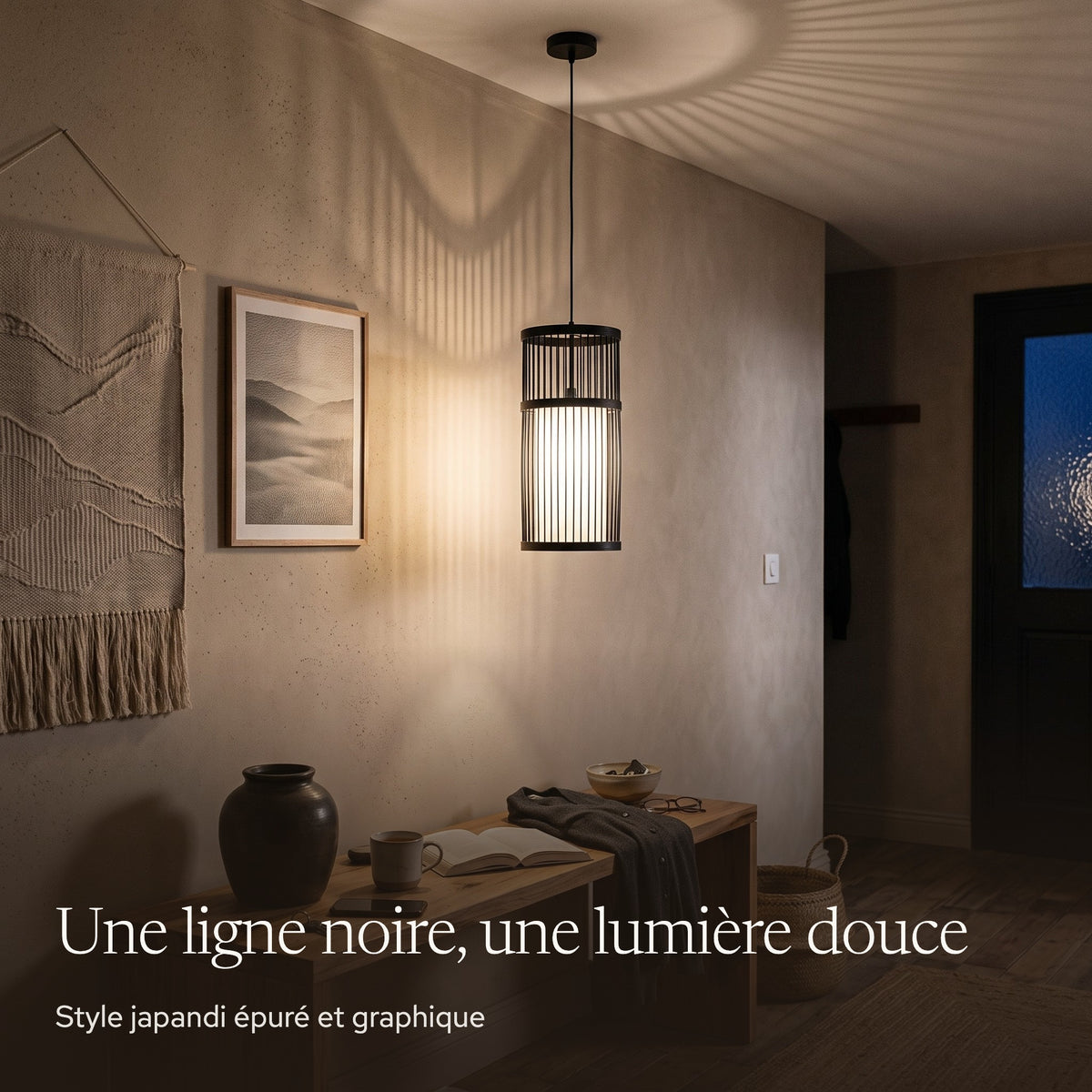 Suspension en bambou cylindre noir allumée le soir dans une entrée japandi