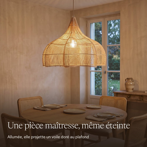 Grande suspension en rotin forme citrouille allumée le soir dans un grand salon japandi